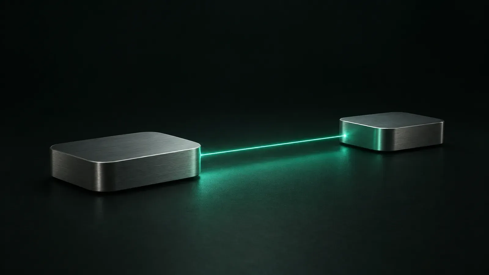 Two low brushed-aluminium boxes rest on a dark green surface, connected by a thin beam of teal light.